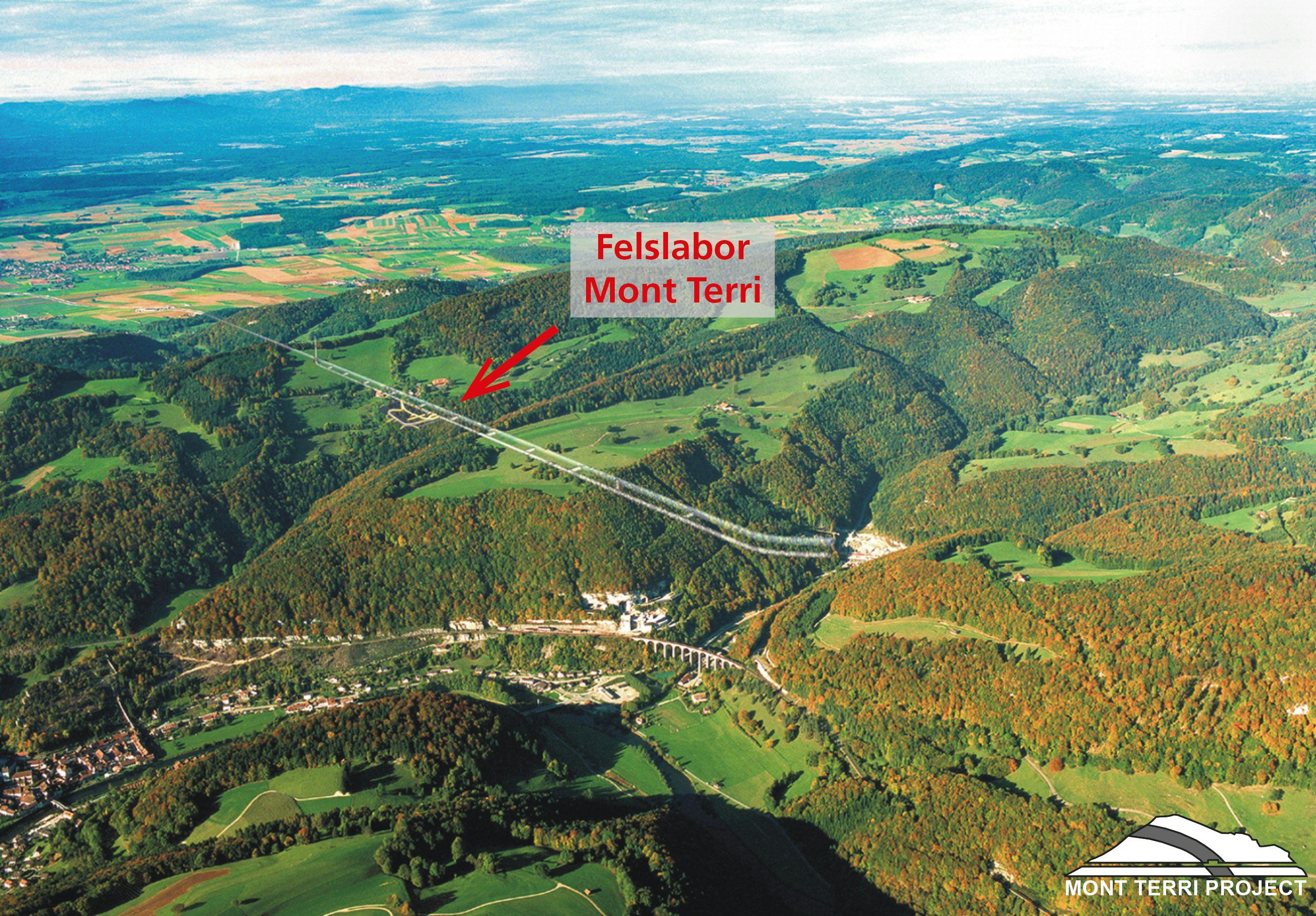 Luftansicht des Mont Terri mit Strassentunnel und Felslabor, der rote Pfeil zeigt die Lage des Felslabors